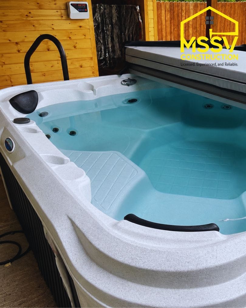 Luxury hot tub with crystal-clear water beside a cedar sauna in a backyard wellness space