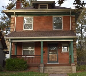 Historic brick home exterior with covered front porch and original architectural details