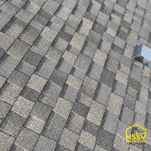 Gray architectural asphalt shingle roof with metal vent after roof replacement
