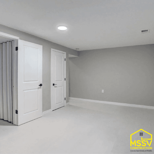 Finished basement remodel with gray walls, white doors, recessed lighting, and new flooring