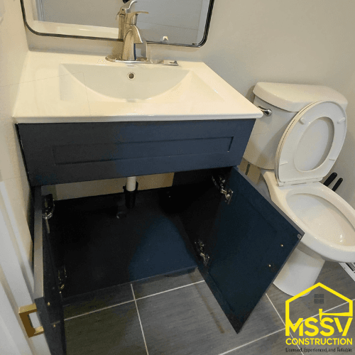 Compact bathroom remodel with black vanity, white sink and modern tile floor