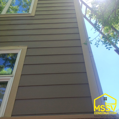Close-up dark gray horizontal exterior siding with white window trim on a residential home by MSSV Construction